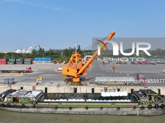 A crane transfers phthalic acid to a truck at the eastern operation area of Siyang Port on the Beijing-Hangzhou Grand Canal in Suqian, China...