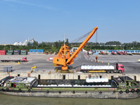 A crane transfers phthalic acid to a truck at the eastern operation area of Siyang Port on the Beijing-Hangzhou Grand Canal in Suqian, China...