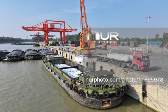 A crane transfers phthalic acid to a truck at the eastern operation area of Siyang Port on the Beijing-Hangzhou Grand Canal in Suqian, China...