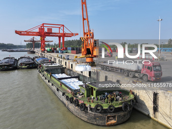 A crane transfers phthalic acid to a truck at the eastern operation area of Siyang Port on the Beijing-Hangzhou Grand Canal in Suqian, China...