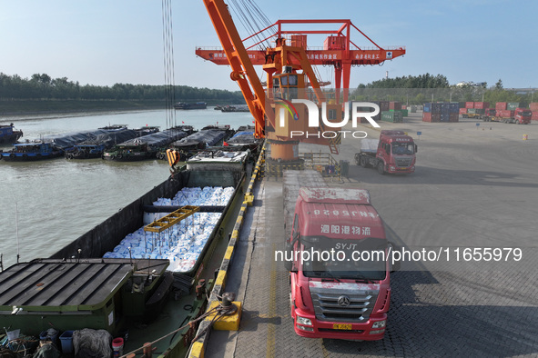 A crane transfers phthalic acid to a truck at the eastern operation area of Siyang Port on the Beijing-Hangzhou Grand Canal in Suqian, China...