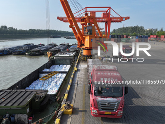 A crane transfers phthalic acid to a truck at the eastern operation area of Siyang Port on the Beijing-Hangzhou Grand Canal in Suqian, China...