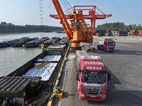 A crane transfers phthalic acid to a truck at the eastern operation area of Siyang Port on the Beijing-Hangzhou Grand Canal in Suqian, China...