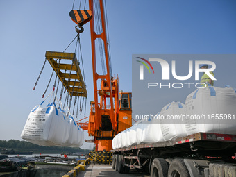 A crane transfers phthalic acid to a truck at the eastern operation area of Siyang Port on the Beijing-Hangzhou Grand Canal in Suqian, China...