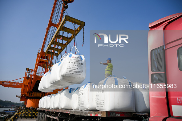 A crane transfers phthalic acid to a truck at the eastern operation area of Siyang Port on the Beijing-Hangzhou Grand Canal in Suqian, China...