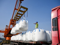 A crane transfers phthalic acid to a truck at the eastern operation area of Siyang Port on the Beijing-Hangzhou Grand Canal in Suqian, China...