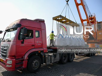 A crane transfers phthalic acid to a truck at the eastern operation area of Siyang Port on the Beijing-Hangzhou Grand Canal in Suqian, China...