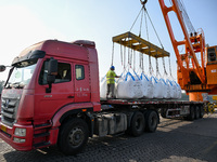 A crane transfers phthalic acid to a truck at the eastern operation area of Siyang Port on the Beijing-Hangzhou Grand Canal in Suqian, China...