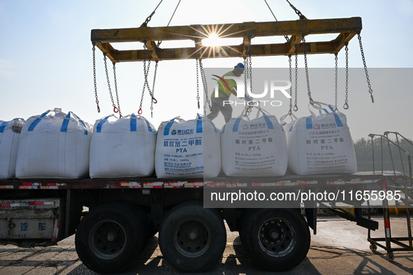 A crane transfers phthalic acid to a truck at the eastern operation area of Siyang Port on the Beijing-Hangzhou Grand Canal in Suqian, China...