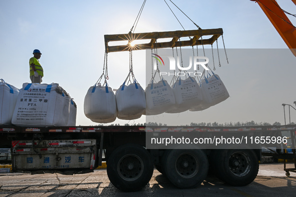 A crane transfers phthalic acid to a truck at the eastern operation area of Siyang Port on the Beijing-Hangzhou Grand Canal in Suqian, China...