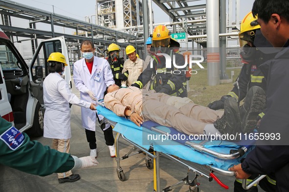 Rescue workers evacuate injured employees during an emergency drill for a fire accident involving a leaking hazardous chemical tank farm in...