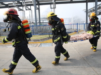 Rescue workers evacuate injured employees during an emergency drill for a fire accident involving a leaking hazardous chemical tank farm in...