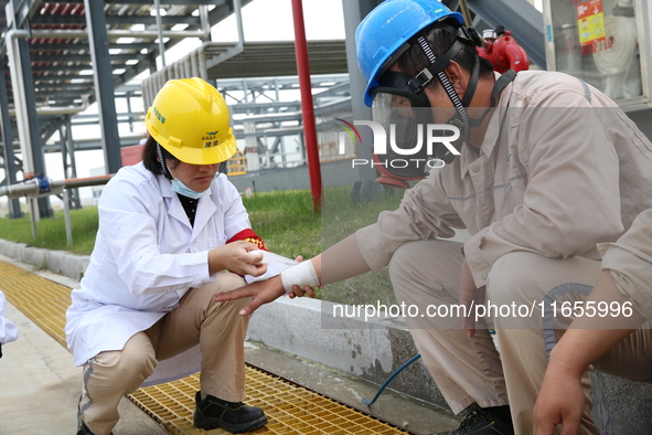 Medical staff bandage the wounds of injured employees during an emergency drill for a fire at a hazardous chemical tank farm in Lianyungang,...