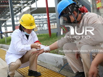 Medical staff bandage the wounds of injured employees during an emergency drill for a fire at a hazardous chemical tank farm in Lianyungang,...