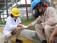 Medical staff bandage the wounds of injured employees during an emergency drill for a fire at a hazardous chemical tank farm in Lianyungang,...