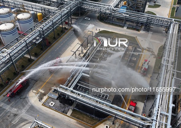 Firefighting equipment is deployed during an emergency drill for a leaking fire at a hazardous chemical tank farm in Lianyungang, Jiangsu pr...