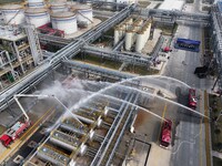 Firefighting equipment is deployed during an emergency drill for a leaking fire at a hazardous chemical tank farm in Lianyungang, Jiangsu pr...