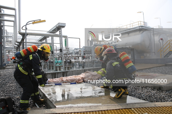 Rescue workers evacuate injured employees during an emergency drill for a fire accident involving a leaking hazardous chemical tank farm in...