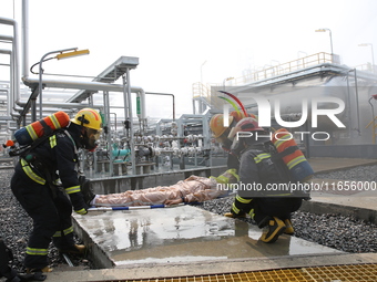 Rescue workers evacuate injured employees during an emergency drill for a fire accident involving a leaking hazardous chemical tank farm in...