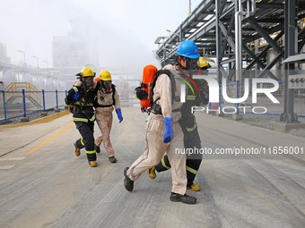 Rescue workers evacuate injured employees during an emergency drill for a fire accident involving a leaking hazardous chemical tank farm in...