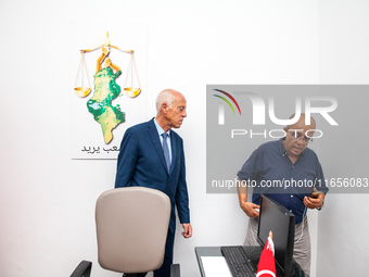 Presidential candidate Kais Saied talks with his brother Naoufel Saied at his campaign headquarters in Tunis, Tunisia, on September 17, 2019...