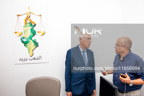 Presidential candidate Kais Saied talks with his brother Naoufel Saied at his campaign headquarters in Tunis, Tunisia, on September 17, 2019...