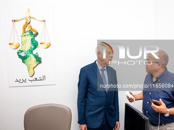 Presidential candidate Kais Saied talks with his brother Naoufel Saied at his campaign headquarters in Tunis, Tunisia, on September 17, 2019...