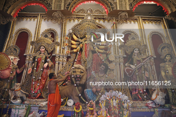 A Hindu priest prays in front of an idol of Durga, the Hindu goddess of power, during a ritual inside a ''pandal'' or temporary platform dur...