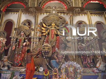 A Hindu priest prays in front of an idol of Durga, the Hindu goddess of power, during a ritual inside a ''pandal'' or temporary platform dur...