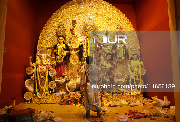 A Hindu priest holds a ''Chamor'' (white synthetic hair) with a brass handle used for Puja Aarti while praying in front of an idol of Durga...