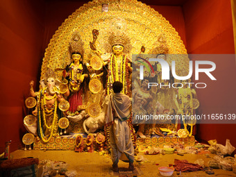 A Hindu priest holds a ''Chamor'' (white synthetic hair) with a brass handle used for Puja Aarti while praying in front of an idol of Durga...