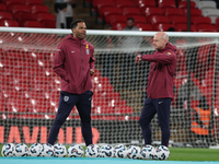 From left to right, Joleon Lescott, interim coach, and Lee Carsley, interim head coach of England, participate in the pre-match warm-up duri...