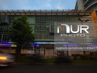 In Medan City, North Sumatra, Indonesia, on October 11, 2024, oil-fueled vehicles pass by an electric fuel filling station during a trial pe...