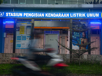 In Medan City, North Sumatra, Indonesia, on October 11, 2024, oil-fueled vehicles pass by an electric fuel filling station during a trial pe...