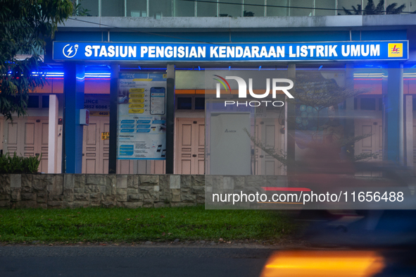 In Medan City, North Sumatra, Indonesia, on October 11, 2024, oil-fueled vehicles pass by an electric fuel filling station during a trial pe...