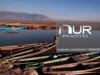 Kashmiri men repair their boats during sunset at Wular Lake in Sopore, Jammu and Kashmir, India, on October 11, 2024 (