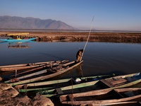 Kashmiri men repair their boats during sunset at Wular Lake in Sopore, Jammu and Kashmir, India, on October 11, 2024 (