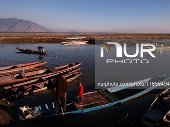 Kashmiri fishermen repair their boats during sunset at Wular Lake in Sopore, Jammu and Kashmir, India, on October 11, 2024. (