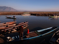 Kashmiri fishermen repair their boats during sunset at Wular Lake in Sopore, Jammu and Kashmir, India, on October 11, 2024. (