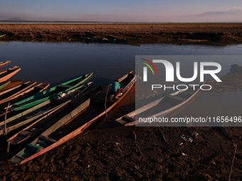 Kashmiri fishermen repair their boats during sunset at Wular Lake in Sopore, Jammu and Kashmir, India, on October 11, 2024. (