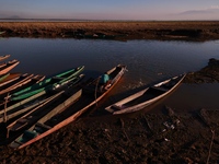 Kashmiri fishermen repair their boats during sunset at Wular Lake in Sopore, Jammu and Kashmir, India, on October 11, 2024. (