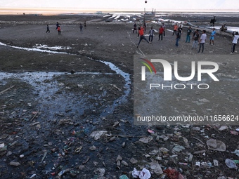 Kashmiri boys play volleyball as garbage is seen all around on the banks of Wular Lake in Sopore, Jammu and Kashmir, India, on October 11, 2...