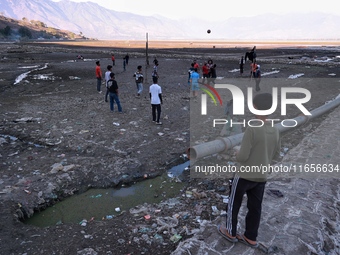 Kashmiri boys play volleyball as garbage is seen all around on the banks of Wular Lake in Sopore, Jammu and Kashmir, India, on October 11, 2...