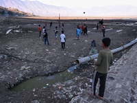 Kashmiri boys play volleyball as garbage is seen all around on the banks of Wular Lake in Sopore, Jammu and Kashmir, India, on October 11, 2...