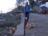 Water falls from a faulty tap as a boy walks on a road near Wular Lake in Sopore, Jammu and Kashmir, India, on October 11, 2024. (