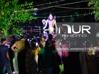 A statue of the Hindu deity Shiva is illuminated at night during the Durga Puja religious festival near a Puja Mandap in Dhaka, Bangladesh,...