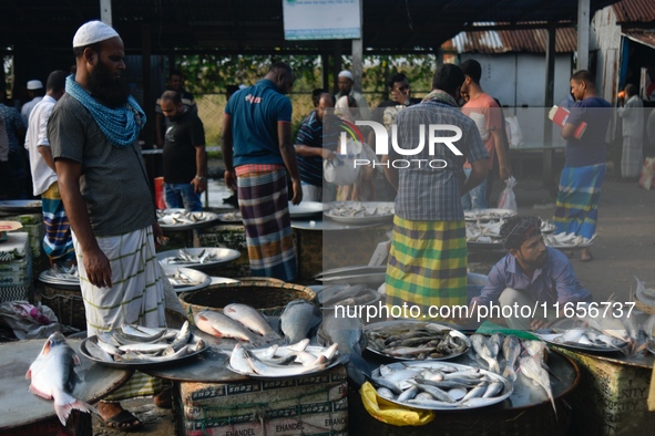 People gather at a wholesale fish market early in the morning near the Padma River in Mawa, Munshiganj, Bangladesh, on October 11, 2024. The...