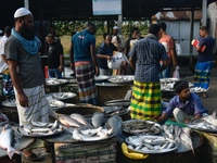 People gather at a wholesale fish market early in the morning near the Padma River in Mawa, Munshiganj, Bangladesh, on October 11, 2024. The...