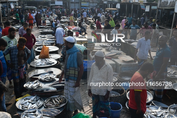 People gather at a wholesale fish market early in the morning near the Padma River in Mawa, Munshiganj, Bangladesh, on October 11, 2024. The...