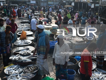 People gather at a wholesale fish market early in the morning near the Padma River in Mawa, Munshiganj, Bangladesh, on October 11, 2024. The...